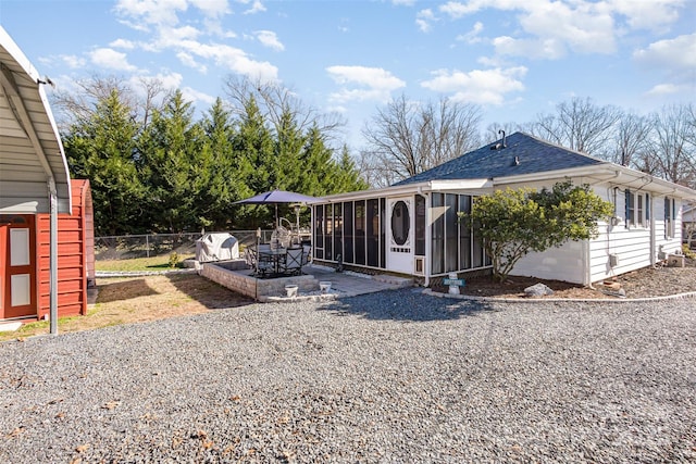 view of side of property with a patio area and a sunroom