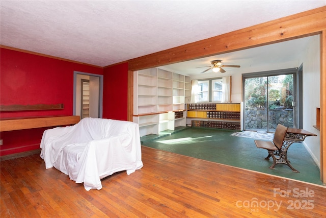 bedroom featuring a textured ceiling, ceiling fan, beamed ceiling, and dark hardwood / wood-style floors