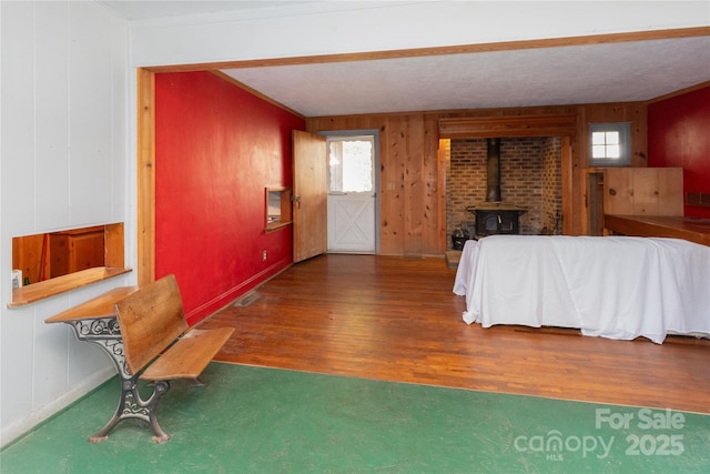 interior space with a wood stove and dark hardwood / wood-style flooring