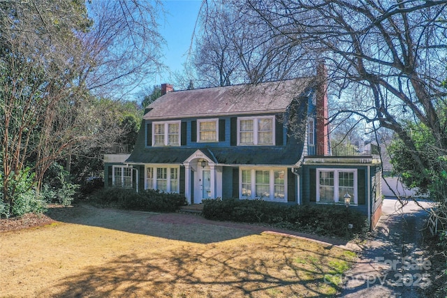 colonial-style house with a front lawn