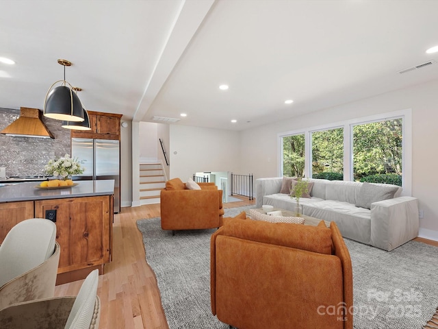 living room with beam ceiling and light hardwood / wood-style floors