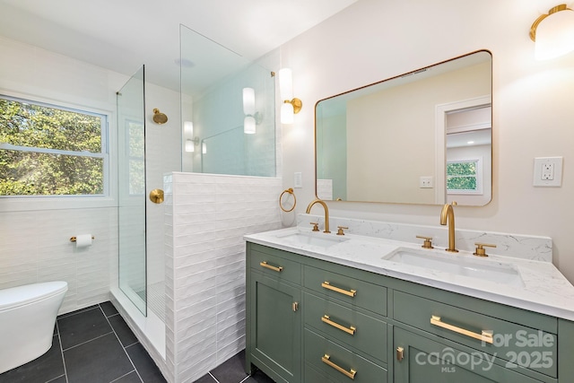 bathroom with a tile shower, tile patterned floors, vanity, and toilet