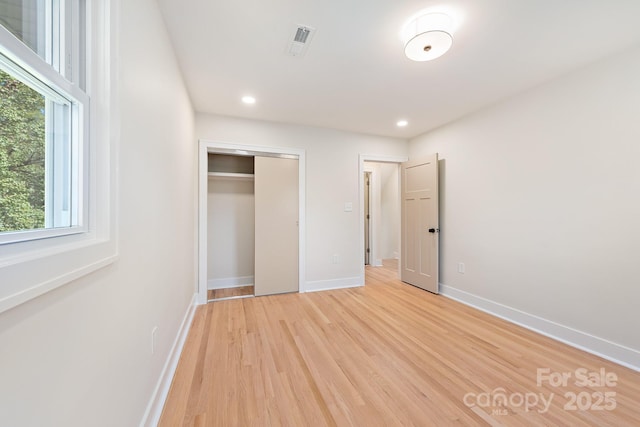 unfurnished bedroom featuring a closet and light wood-type flooring