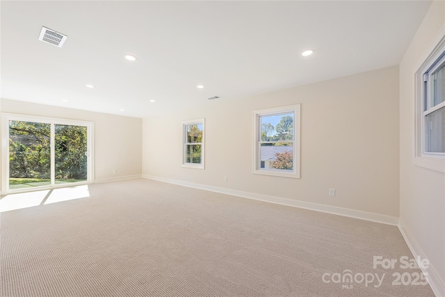 carpeted spare room featuring plenty of natural light