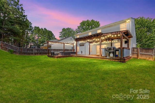 back house at dusk featuring a pergola, a yard, and a deck