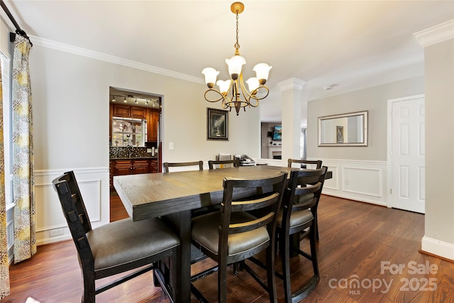 dining space featuring a chandelier, dark hardwood / wood-style flooring, rail lighting, and ornamental molding