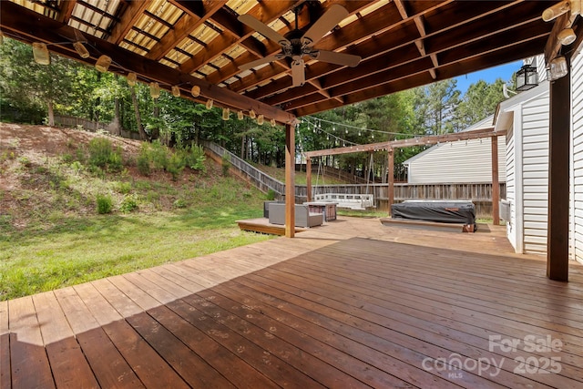 deck with a lawn, ceiling fan, and a hot tub