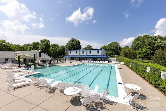 view of pool with a water slide and a patio