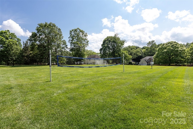 view of community with volleyball court and a yard