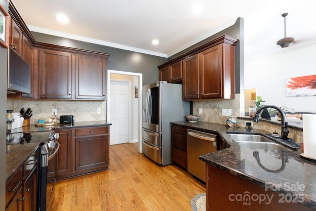 kitchen featuring backsplash, dark stone counters, sink, light hardwood / wood-style floors, and stainless steel appliances