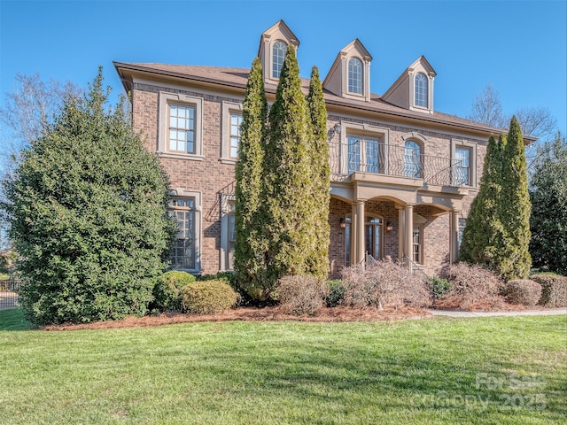 view of front of property with a balcony and a front lawn