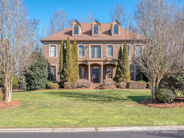 view of front of property featuring a front yard and a balcony