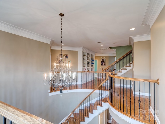 stairs featuring a notable chandelier and crown molding