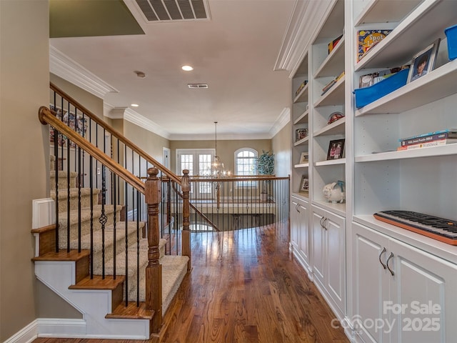 hall with an inviting chandelier, crown molding, and dark hardwood / wood-style floors