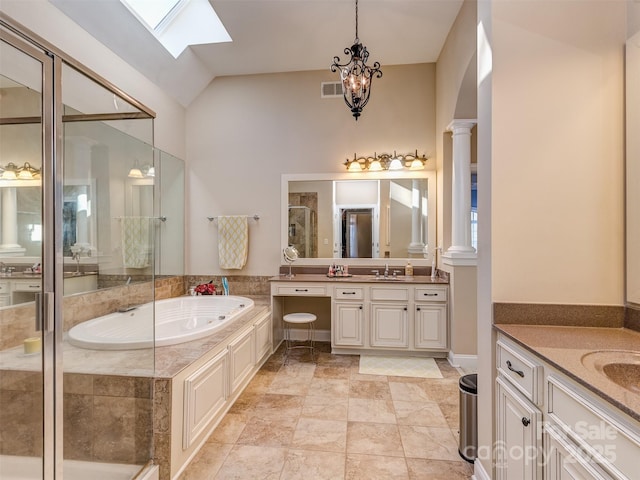 bathroom featuring ornate columns, shower with separate bathtub, vanity, and lofted ceiling with skylight