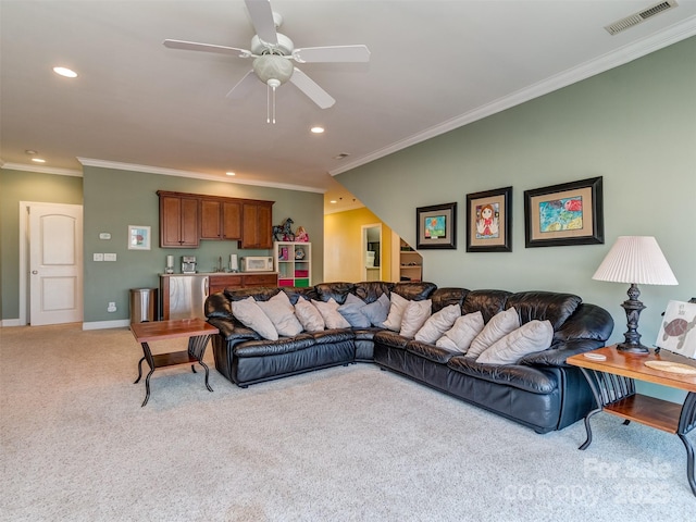 living room with ornamental molding, ceiling fan, and light colored carpet