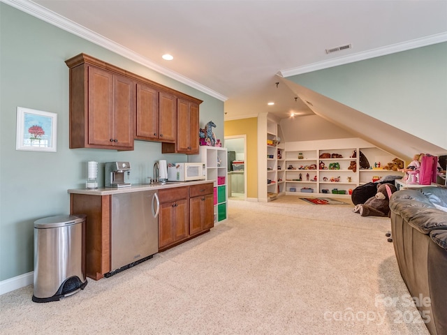 kitchen with sink, ornamental molding, built in features, and light colored carpet