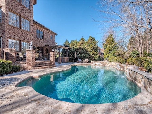 view of swimming pool featuring a patio, pool water feature, and a pergola