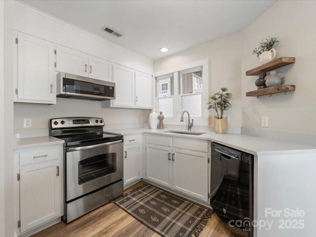 kitchen featuring stainless steel appliances, sink, light hardwood / wood-style flooring, and white cabinets