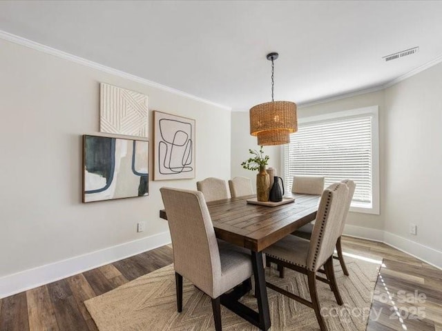 dining room with crown molding and hardwood / wood-style floors