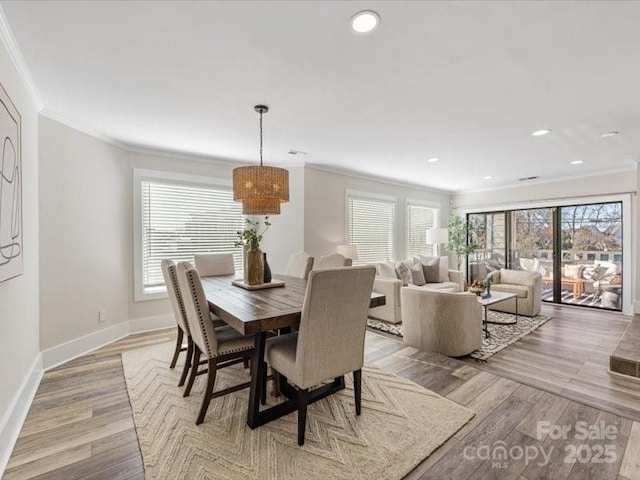 dining area featuring plenty of natural light, ornamental molding, and light hardwood / wood-style floors