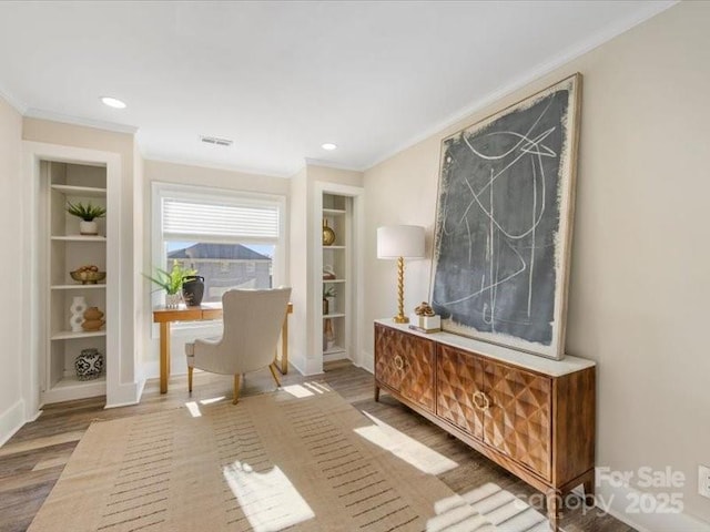 home office with hardwood / wood-style floors, crown molding, and built in features