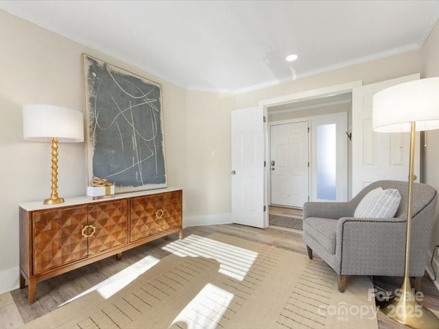 living area featuring crown molding and wood-type flooring