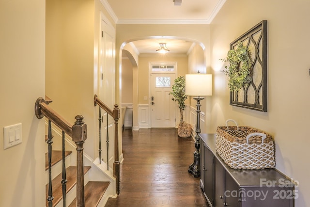 interior space featuring crown molding, arched walkways, and dark wood-type flooring