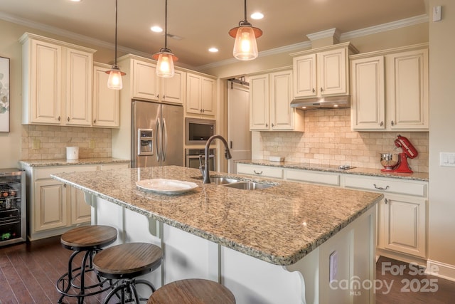 kitchen with stainless steel appliances, ornamental molding, a sink, and under cabinet range hood