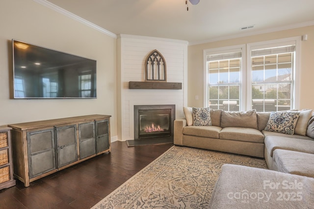 living area with a fireplace, ornamental molding, and dark wood-style flooring