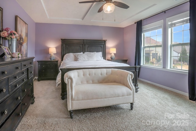 bedroom with ceiling fan, multiple windows, light colored carpet, and baseboards