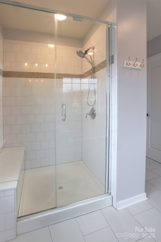 full bathroom with tile patterned flooring and a shower stall