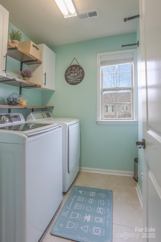 clothes washing area with visible vents, separate washer and dryer, cabinet space, and baseboards