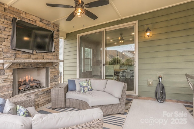 view of patio / terrace with an outdoor living space with a fireplace and ceiling fan