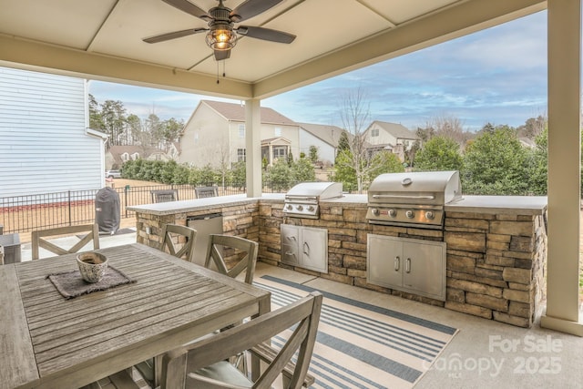 view of patio / terrace with outdoor dining space, a grill, an outdoor kitchen, and fence