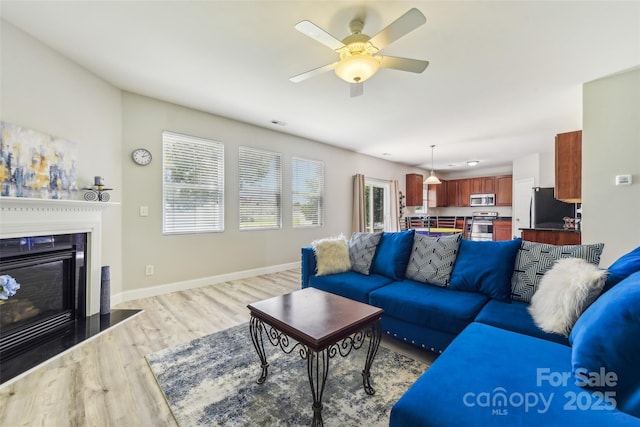 living room with light hardwood / wood-style flooring and ceiling fan