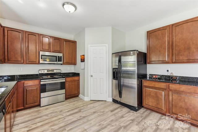 kitchen with light hardwood / wood-style floors and appliances with stainless steel finishes