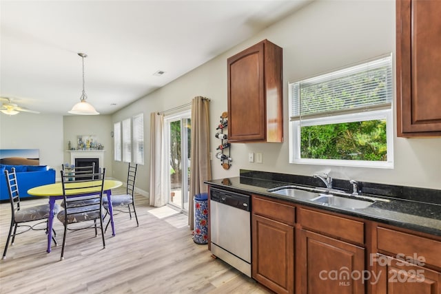 kitchen featuring dishwasher, hanging light fixtures, dark stone countertops, and sink