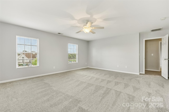 unfurnished room with ceiling fan, light carpet, and a wealth of natural light