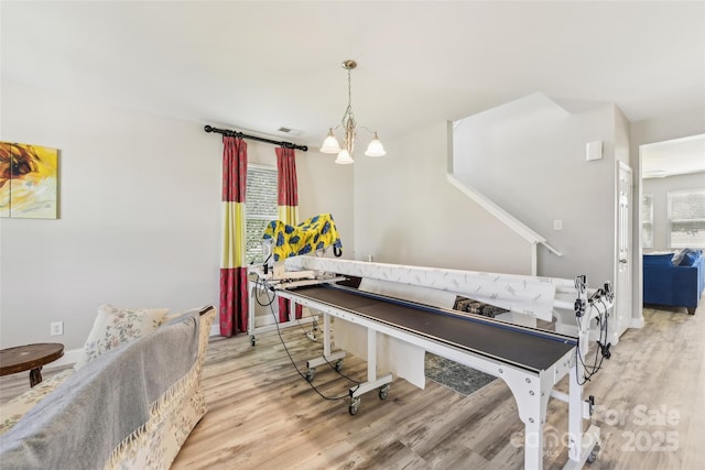 playroom featuring a chandelier and light hardwood / wood-style floors