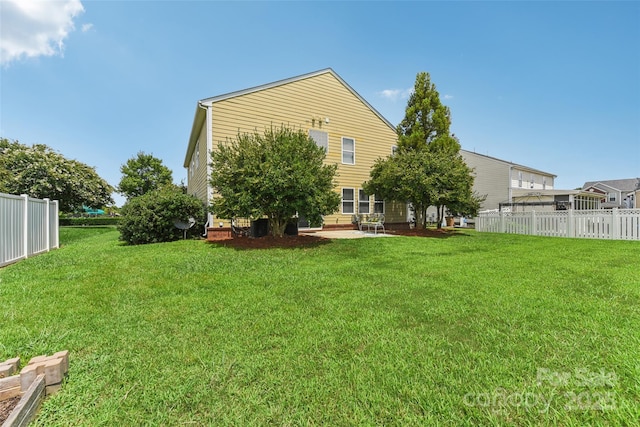 rear view of property featuring a patio and a lawn