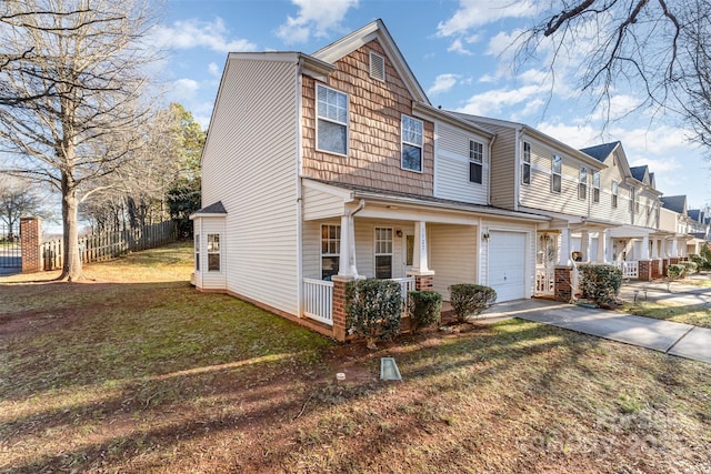 view of front of home featuring a porch, a front yard, and a garage