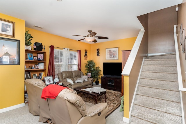 carpeted living room with ceiling fan