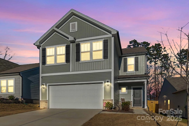 view of front of house with driveway, stone siding, board and batten siding, and an attached garage