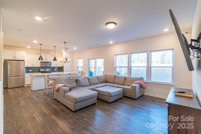 living room featuring baseboards, dark wood-type flooring, and recessed lighting