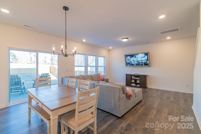 dining area featuring dark wood-style flooring, recessed lighting, visible vents, and a notable chandelier