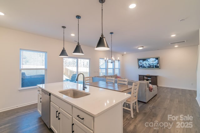 kitchen featuring dark wood-type flooring, open floor plan, a sink, and stainless steel dishwasher