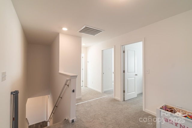 hall with visible vents, carpet floors, an upstairs landing, and baseboards