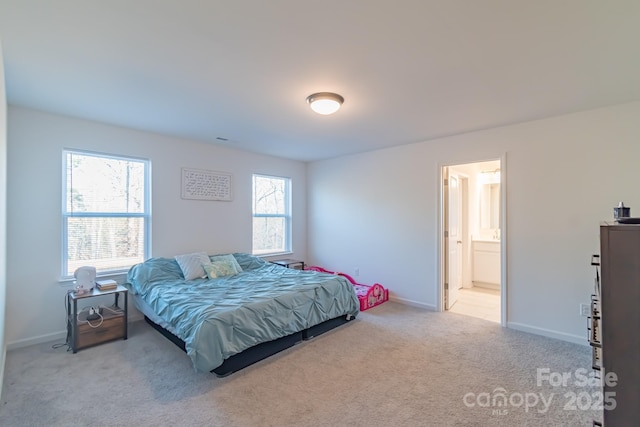 carpeted bedroom with baseboards and ensuite bathroom