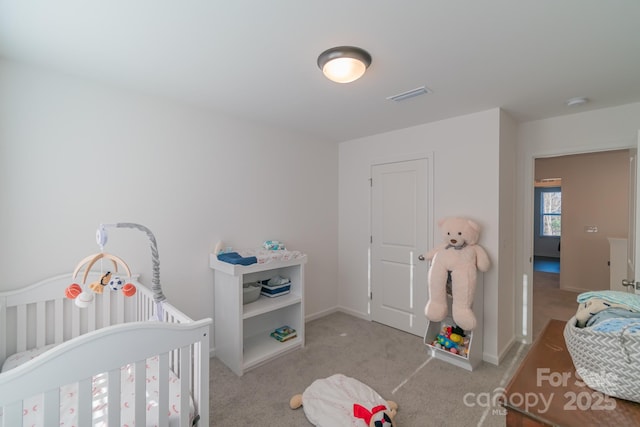 bedroom featuring a nursery area, carpet flooring, visible vents, and baseboards